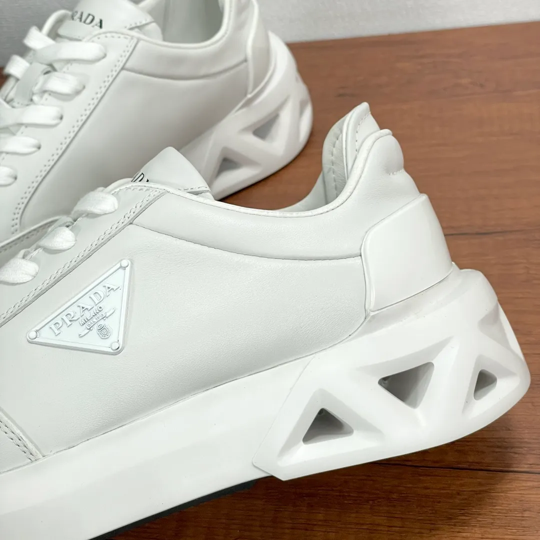 💰780 Code: YS003645 Prada/Prada men's new leather sneakers. This leather sneaker presents a modern version, reinterpreting the brand's archive style with clean lines and smooth details. The shoes are made of imported calf leather, which is fine, soft and resistant to creases. It is decorated with a triangular metal logo on the outside, bright TPU decoration on the heel, and a longer and padded inner heel design, making it more comfortable to wear. The tongue is decorated with a silk-screen logo, and is paired with a hollow rubber sole on the heel. The full cowhide lining comes standard with logo cowhide feet, making the upper foot more comfortable, versatile and durable! Comes with full original packaging! Code number: 39-40-41-42-43-44 Standard leather shoe size (45 can be customized and does not support returns) Item number: 2EE918 leather white